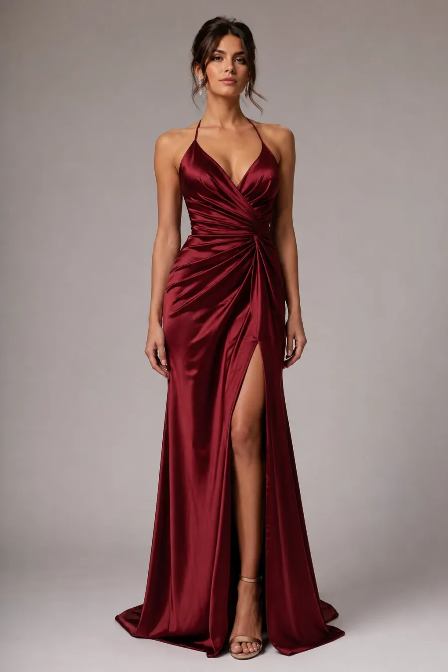 Full-body shot of a black-tie gala gown — a floor-length burgundy satin evening gown on a plain studio background, clean elegant lighting
