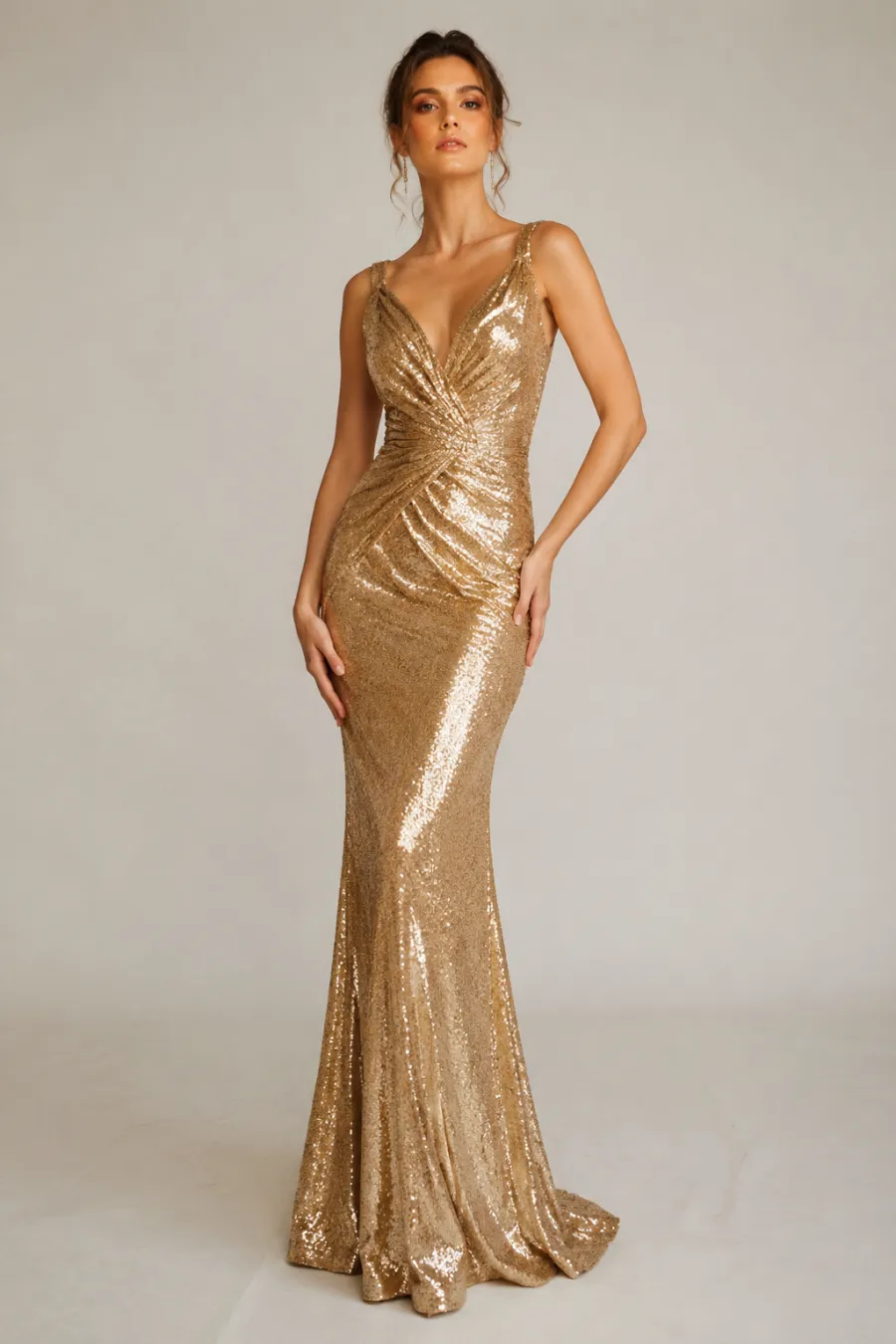 Full-body shot of a metallic gold sequined floor-length evening gown for a glam gala, shown on a plain light background with soft natural lighting