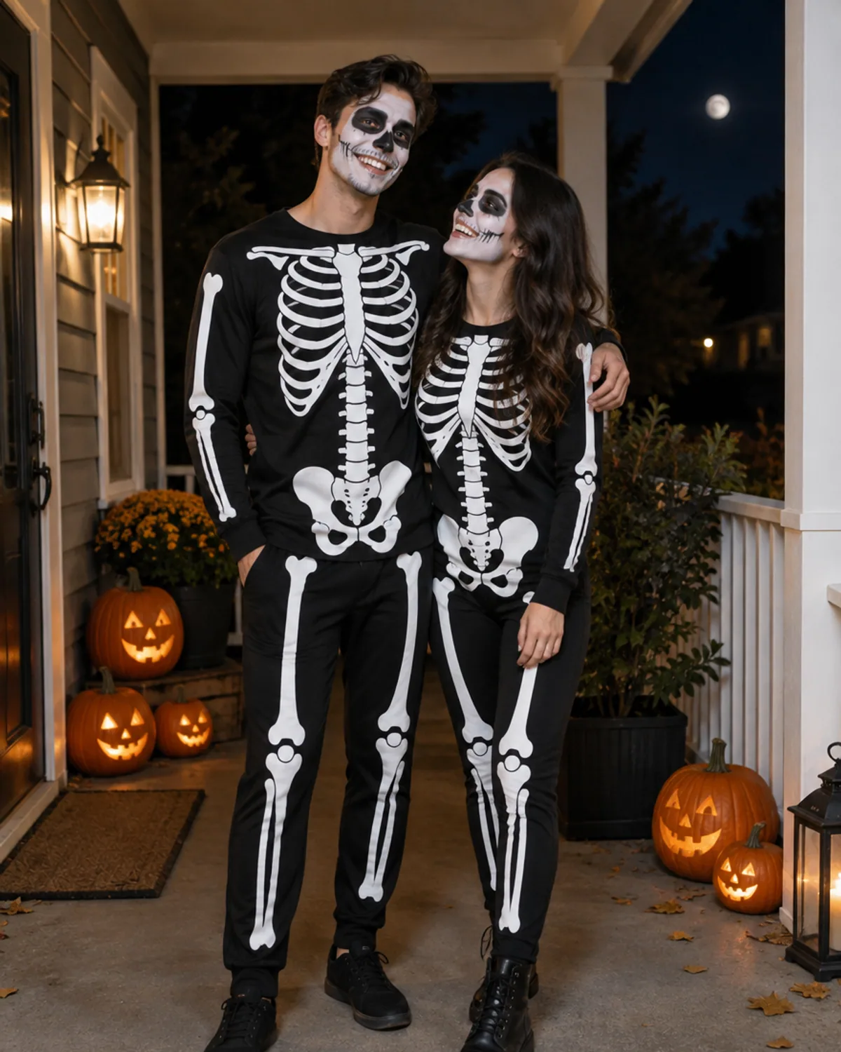 Adult couple in matching skeleton costumes with skull face paint on a porch with pumpkins